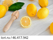 Ripe juicy lemons and squeezer on light table. Стоковое фото, фотограф Pixel_shot / Фотобанк Лори