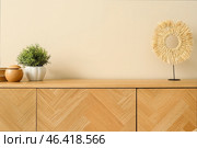 Modern humidifier and houseplant on wooden cabinet near beige wall. Стоковое фото, фотограф Pixel_shot / Фотобанк Лори