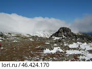 Уральские горы. Скальные выходы, скалы, останцы, вершины, каменные истуканы, с туристом хвойные растения  Красные ягоды и зеленые листья  брусники и голубики под снегом на склонах горного хребта "Серебрянский " Конжаковско-Серебрянский горный массив, плато Серебрянского камня осень.Ural Mountains. Rocky outcrops, cliffs, remnants, peaks, stone idols, with a tourist coniferous plants Red berries and green leaves of lingonberries and blueberries under the snow on the slopes of the Serebryansky mountain range Konzhakovsko-Serebryansky mountain range, Serebryansky stone plateau autumn. (2012 год). Стоковое фото, фотограф Юрий Карачев / Фотобанк Лори