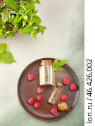 Bottles of raspberry essential oil on color background. Стоковое фото, фотограф Pixel_shot / Фотобанк Лори