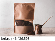 Bag with coffee powder and jezve on table. Стоковое фото, фотограф Pixel_shot / Фотобанк Лори