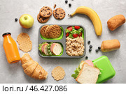 Lunchboxes with delicious food and bottle of juice on grunge grey background. Стоковое фото, фотограф Pixel_shot / Фотобанк Лори