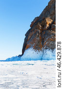 Winter landscape of frozen Baikal Lake. View of natural landmark of Olkhon Island, famous Cape Khoboy, called Deva Rock on sunny February day. Tourist attraction for active recreation. Стоковое фото, фотограф Виктория Катьянова / Фотобанк Лори