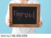 Doctor holding chalkboard with text THYROID, closeup. Concept of thyroid disease. Стоковое фото, фотограф Pixel_shot / Фотобанк Лори