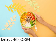 Женщина ест вкусный рис тыкать миской на цветном фоне. Стоковое фото, фотограф Pixel_shot / Фотобанк Лори