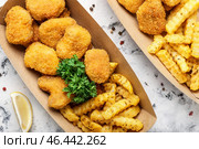 Вкусные наггетсы и картофель фри в бумажной коробке на светлом фоне. Стоковое фото, фотограф Pixel_shot / Фотобанк Лори