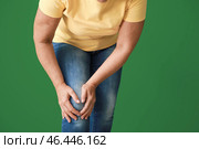 Зрелая женщина страдает от боли в колене на цветном фоне. Стоковое фото, фотограф Pixel_shot / Фотобанк Лори