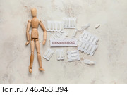 Деревянная человеческая фигура с геморроидальными суппозиториями на светлом фоне. Стоковое фото, фотограф Pixel_shot / Фотобанк Лори