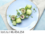 Тарелка с вкусными рулетиками из огурцов на цветном фоне. Стоковое фото, фотограф Pixel_shot / Фотобанк Лори
