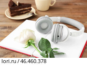 Раскройте книгу, цветок, чашку кофе и торт на деревянной предпосылке. Концепция аудиокниги. Стоковое фото, фотограф Pixel_shot / Фотобанк Лори