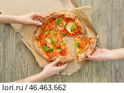 Люди берут кусочки вкусной пиццы Маргариты со стола. Стоковое фото, фотограф Pixel_shot / Фотобанк Лори