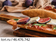 Вкусный бутерброд с спелый инжир, прошутто и сыр бри на деревянной доске, крупным планом. Стоковое фото, фотограф Pixel_shot / Фотобанк Лори