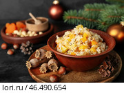 Доска с миской риса Кутя, орехами, еловыми шишками и маком на темном столе, крупным планом. Стоковое фото, фотограф Pixel_shot / Фотобанк Лори