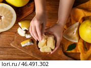 Женские руки с кусочками свежих фруктов помело на деревянном фоне. Стоковое фото, фотограф Pixel_shot / Фотобанк Лори
