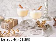 Стаканы вкусного коктейля из гоголя-моголь, рождественский подарок и декор на светлом фоне. Стоковое фото, фотограф Pixel_shot / Фотобанк Лори