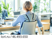 Office worker wearing posture corrector brace while sitting at desk. Стоковое AI-изображение, AI-художник Юрий Поздников / Фотобанк Лори