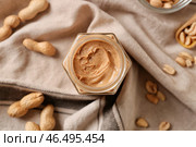 Баночка со вкусным арахисовым маслом на тканевом фоне. Стоковое фото, фотограф Pixel_shot / Фотобанк Лори