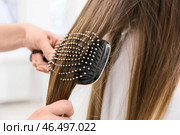 Женщина-парикмахер расчесывает волосы клиента в салоне красоты, крупным планом. Стоковое фото, фотограф Pixel_shot / Фотобанк Лори