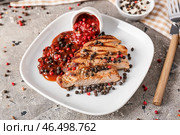 Тарелка с вкусным жареным мясом и перечным соусом на фоне гранж. Стоковое фото, фотограф Pixel_shot / Фотобанк Лори