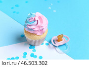 Вкусный кекс с конфетти и пустышкой на голубом фоне. Концепция вечеринки для раскрытия пола ребенка. Стоковое фото, фотограф Pixel_shot / Фотобанк Лори