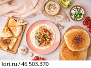 Вкусный лепешка с жареными овощами, хумусом и соусом на белом фоне. Стоковое фото, фотограф Pixel_shot / Фотобанк Лори