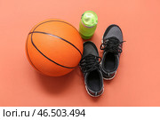 Кроссовки, спортивная бутылка и баскетбольный мяч на оранжевом фоне. Стоковое фото, фотограф Pixel_shot / Фотобанк Лори
