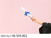 Женская рука с дипломом на розовом фоне. Стоковое фото, фотограф Pixel_shot / Фотобанк Лори