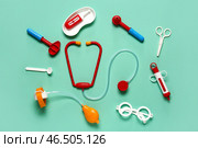 Игрушечная аптечка с стетоскопом, шприцем и молоточком для проверки рефлексов на бирюзовом фоне. Вид сверху. Стоковое фото, фотограф Pixel_shot / Фотобанк Лори