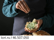 Молодая женщина, посыпая сыр на кусок свежего хлеба с зеленым маслом на темном фоне, крупным планом. Стоковое фото, фотограф Pixel_shot / Фотобанк Лори