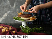 Женский кондитер украшает вкусный торт за столом. Стоковое фото, фотограф Pixel_shot / Фотобанк Лори