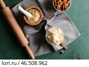 Вкусная миндальная мука с хлопьями и орехами на цветном столе. Стоковое фото, фотограф Pixel_shot / Фотобанк Лори