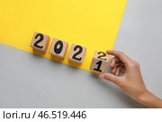 Женская рука превращает фигуру 2021 в 2022 на цветном фоне. Стоковое фото, фотограф Pixel_shot / Фотобанк Лори