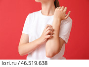 Молодая женщина чешется на цветном фоне. Стоковое фото, фотограф Pixel_shot / Фотобанк Лори