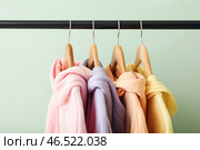 Стойка с модными худи возле зеленой стены, крупным планом. Стоковое фото, фотограф Pixel_shot / Фотобанк Лори