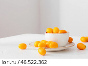 Миска с вкусными фруктами кумкват на столе в комнате. Стоковое фото, фотограф Pixel_shot / Фотобанк Лори