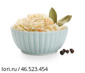 Миска квашеной капусты с лавровыми листьями и горошком на белом фоне. Стоковое фото, фотограф Pixel_shot / Фотобанк Лори