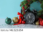 Будильник, венок, бубенец и украшения на синем фоне. Концепция обратного отсчета до Рождества. Стоковое фото, фотограф Pixel_shot / Фотобанк Лори