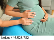 Красивая молодая беременная женщина и доула тренируются с фитболом дома, крупный план. Стоковое фото, фотограф Pixel_shot / Фотобанк Лори