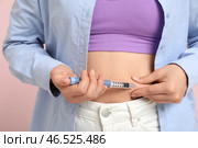 Молодая женщина с диабетом использует ланцетную ручку на розовом фоне, крупным планом. Стоковое фото, фотограф Pixel_shot / Фотобанк Лори
