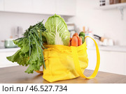 Жёлтая сумка-шоппер, полная фруктов и овощей, на кухне. Стоковое фото, фотограф Pixel_shot / Фотобанк Лори