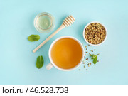Чашка вкусного гречишного чая, мед и мята на голубом фоне. Стоковое фото, фотограф Pixel_shot / Фотобанк Лори