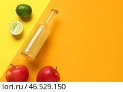 Композиция с бутылкой вкусного газированного напитка, яблоками и лаймом на цветном фоне. Стоковое фото, фотограф Pixel_shot / Фотобанк Лори