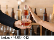 Мужчина с бокалом виски и женщина отказываются пить в баре. Стоковое фото, фотограф Pixel_shot / Фотобанк Лори