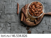 Деревянная доска с орехами пекан и специями на сером столе. Стоковое фото, фотограф Pixel_shot / Фотобанк Лори