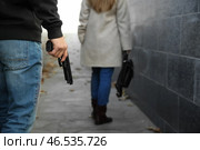 Мужчина-вор с пистолетом собирается украсть у женщины на улице. Стоковое фото, фотограф Pixel_shot / Фотобанк Лори