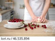 Чаша с вишней и женщина месит тесто на кухне, крупный план. Стоковое фото, фотограф Pixel_shot / Фотобанк Лори