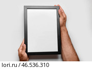 Мужчина, держащий пустую фоторамку на белом фоне. Стоковое фото, фотограф Pixel_shot / Фотобанк Лори