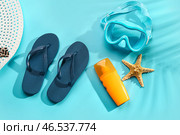 Женские стильные шлепанцы с кремом для загара и маской для сноркелинга на голубом фоне. Стоковое фото, фотограф Pixel_shot / Фотобанк Лори