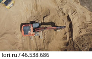 A large orange excavator is digging into a sandy area. Стоковое видео, видеограф Скрипачев Антон / Фотобанк Лори