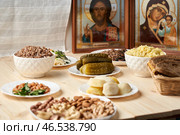 Moscow February 15 2025, a wooden table with lean food and Orthodox icons The concept of an Orthodox post. Редакционное фото, фотограф Скрипачев Антон / Фотобанк Лори
